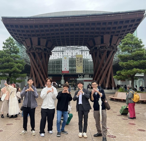 A group photo in front of the Tsuzumi-mon Gate at Kanazawa Station.